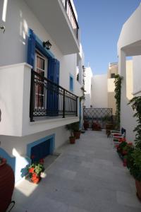 a courtyard of a building with blue doors and potted plants at Antonio Studios in Naxos Chora