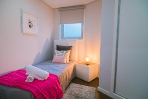 een kleine slaapkamer met een bed en een raam bij Lechartier Oporto apartments 1 in Porto