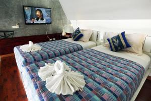 a hotel room with two beds with towels on them at Phuket Paradiso in Chalong 