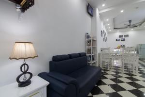 a living room with a blue couch and a lamp at Hanoi Boutique House in Hanoi