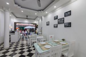 a dining room with a table and white chairs at Hanoi Boutique House in Hanoi