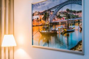 a painting of a bridge with boats in the water at Lechartier Oporto apartments 3 in Porto