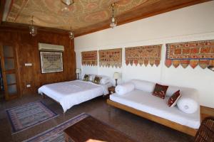 a bedroom with two beds and a couch in it at Kankarwa Haveli in Udaipur