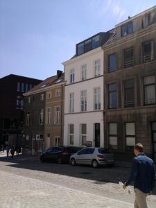 een man die door een straat loopt voor gebouwen bij Designflats Gent in Gent