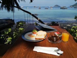 una mesa con un plato de desayuno y vistas al océano en Koh Tao Royal Resort en Ko Tao