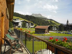 a balcony with a chair and flowers in a town at Apart-Hotel Filomena in Lech am Arlberg