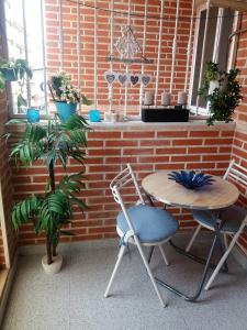 トレビエハにあるAMAZING SUNNY FLAT WITH BALCONY POOL two MINS FROM THE BEACHのテーブルと椅子2脚、テーブルと植物