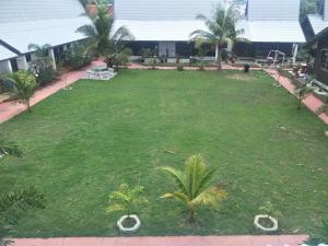 un gran césped con palmeras en un patio en Rasa Senang Villa -Islam Guest Only, en Pantai Cenang