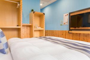 a bedroom with a bed and a flat screen tv at Yuan Su B&B in Yuchi