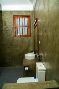 a bathroom with a toilet and a sink and a window at Goyambokka Guesthouse in Tangalle +37 photos