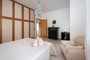 サン・ヴィート・ロ・カーポにあるVilletta di babiのベッドルーム(白いベッド1台、ソファ付)