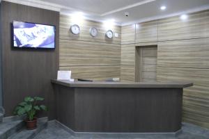 阿斯塔纳Hotel Inju Hills的大堂设有前台,墙上挂有时钟