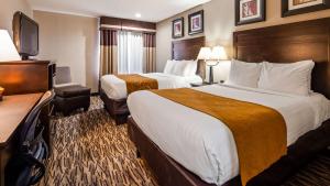 Habitación de hotel con 2 camas y TV de pantalla plana. en Best Western Lafayette Inn en Lafayette