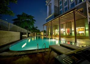 a swimming pool in front of a building at night at Goldfinch Hotel Delhi NCR in Faridabad