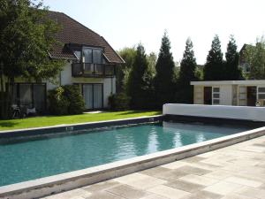 a swimming pool in front of a house at Fletcher Hotel-Restaurant de Witte Brug in Lekkerkerk