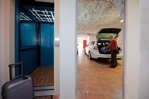 a man standing next to a car in a garage at Casa Le Terrazze in Positano