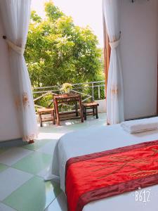 a bedroom with a bed and a balcony with a table at Tam Coc - Thành Homestay in Ninh Binh