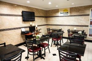 a restaurant with tables and chairs and a tv on the wall at Days Inn by Wyndham Concord in Concord