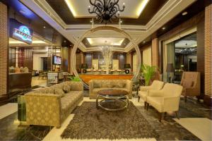 a lobby with couches and chairs and a mirror at Goldfinch Hotel Delhi NCR in Faridabad
