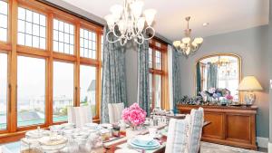 uma sala de jantar com uma mesa e um lustre em Dyers House em Christchurch