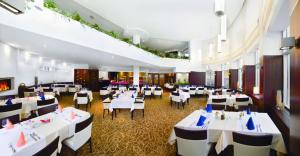 un comedor con mesas y sillas blancas en Hotel Exclusive, en Sarajevo