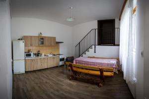 a room with a kitchen with a bed and a refrigerator at Casa din Barcut in Bărcuţ