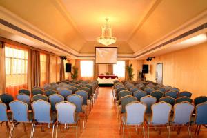 a large room with chairs and a projection screen at Regant Lake Palace Hotel in Nīndakara
