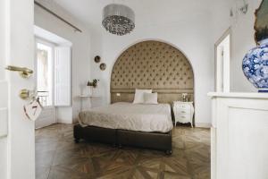 a bedroom with a bed with a large headboard at B&B Palazzo del Teatro in Agrigento