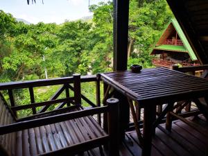 a wooden table and bench on a porch with a view at Koh Tao Royal Resort in Ko Tao