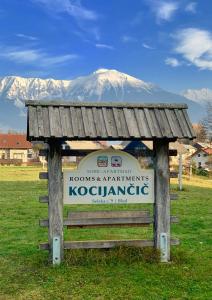 een bord in een veld met een berg op de achtergrond bij Apartments-Rooms Kocijancic in Bled