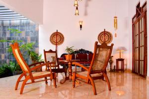 a dining room with a table and four chairs at Thambara Villa Unawatuna in Unawatuna