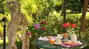 uma estátua de uma rapariga sentada numa mesa com uma mesa em Hotel Villa Clementina em Bracciano