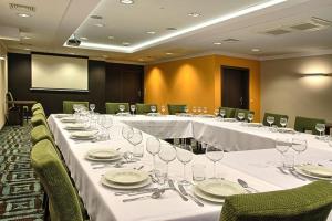 a conference room with a long table with plates and wine glasses at Hotel & Browar Słociak in Opole