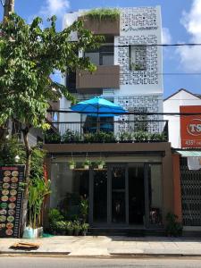 a restaurant with a blue umbrella on a building at La An Homestay in Hoi An