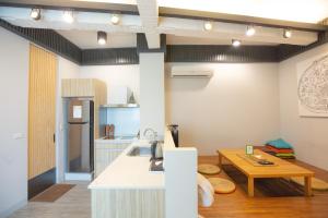 a kitchen with a white counter and a wooden table at 小城門 親子寵物包棟民宿 City Door Family and Pet-Friendly Entire Homes in Tainan