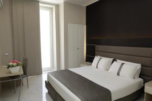a bedroom with a large white bed and a window at Hotel Vergilius Billia in Naples