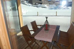 a table with two chairs and a vase on a porch at Appartements Christine in Bezau