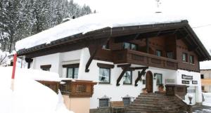 uma casa com telhado coberto de neve e escadas em Appartment Valnova / Barga em Partenen