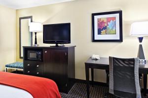 una camera d'albergo con un letto e una scrivania con una televisione di Holiday Inn Express Hotel Fort Campbell-Oak Grove by IHG a Oak Grove