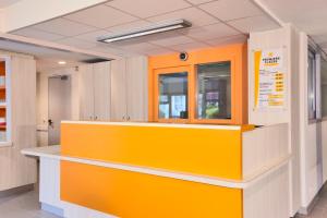 un comptoir jaune et blanc dans une salle d'hôpital dans l'établissement Premiere Classe Bordeaux Nord - Lac, à Bordeaux