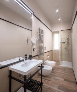 La salle de bains est pourvue d'un lavabo blanc et de toilettes. dans l'établissement Rainbow Suite, à Cassino