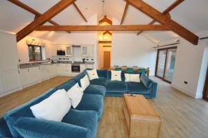a living room with a blue couch and a table at Moulton-Barrett Barn in Bideford
