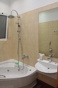 a bathroom with a shower and a tub and a sink at Deves Hotel in Nafplio