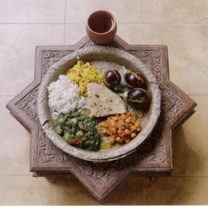 un plato de comida con arroz y verduras en una mesa en Apani Dhani Eco-Lodge, en Nawalgarh