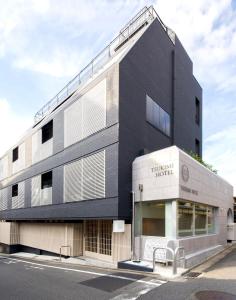 een zwart-wit gebouw met een bank ervoor bij TSUKIMI HOTEL in Kyoto