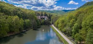 NagyhutaKőkapu Vadászkastély és Hotel & Apartments的河中房屋的正面景色