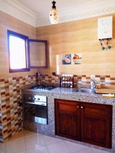 een keuken met een wastafel en een fornuis top oven bij Casa Mogador in Essaouira