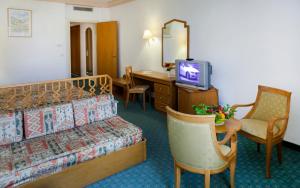 a hotel room with a bed and a desk and a television at El Mouradi Douz in Douz