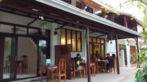 a group of people sitting at tables outside a restaurant at Villa Boua Thong Hotel in Luang Prabang