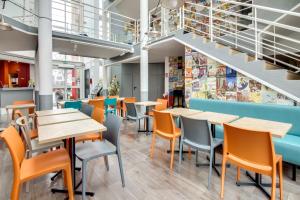 a restaurant with tables and chairs and stairs at HotelF1 Bourges Le Subdray in Bourges
